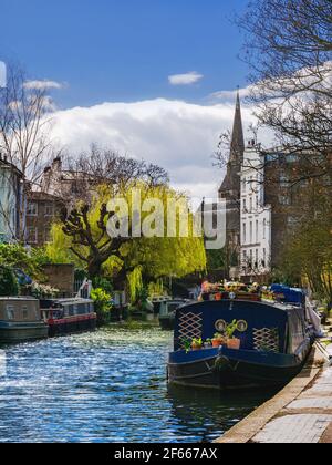 Canal de Grand Union au printemps avec un bateau à moteur amarré lors d'une journée ensoleillée à Londres, Angleterre Banque D'Images