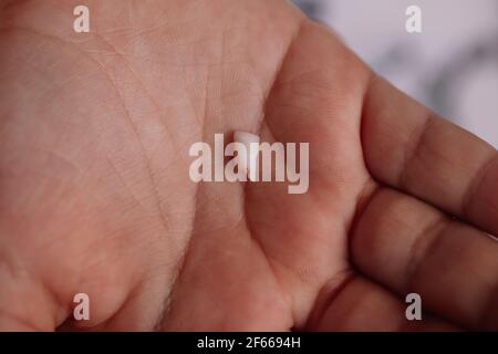 gros plan de la première dent de bébé tombée avec du sang et des racines, l'incisive avant dans la paume du médecin ou de la mère Banque D'Images