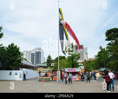 Asakusa, Tokyo, Japon - Koinobori, chaussettes à vent en forme de carpe pour la Journée des enfants et vendeur de rue à Senso-ji, le plus ancien temple de Tokyo. Banque D'Images