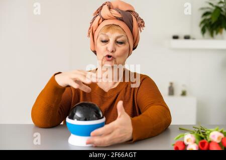 mains d'un titreur de fortune travaillant avec une boule de cristal brillante Banque D'Images