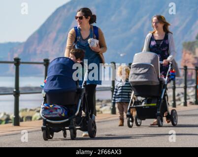 Sidmouth, Devon, Royaume-Uni. 30 mars 2021. Météo au Royaume-Uni: On a vu des gens se promener le long de la jolie esplanade et profiter du soleil chaud dans la jolie station regency de Sidmouth cet après-midi. Credit: Celia McMahon/Alamy Live News Banque D'Images