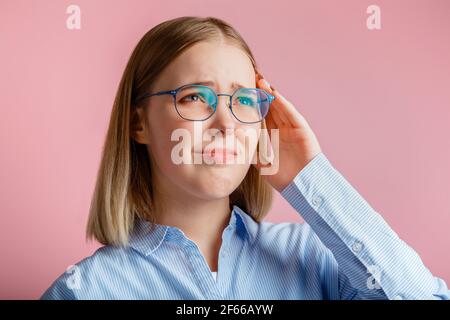 La femme souffre de maux de tête de stress. Triste bouleversé affectif portrait travailleur de bureau ou étudiant dans des lunettes malades avec la migraine et tient le temple avec han Banque D'Images