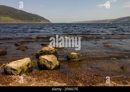 Grands Boulders au bord de l'eau du Loch Ness Scotland, par une journée de vent clair Banque D'Images