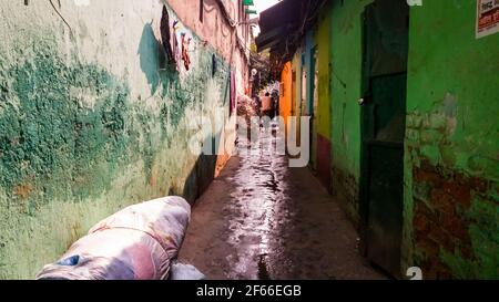 Kolkata, Bengale-Occidental, Inde - janvier 2018: Une ruelle étroite qui traverse un bidonville avec les rues mouillées avec de l'eau dans la région de Kumartuli de la Banque D'Images