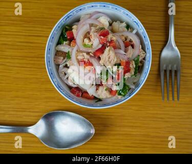 Le merlu péruvien et le ceviche de légumes, d'épices et de chaux dans un bol en céramique avec des couverts. Vue de dessus Banque D'Images