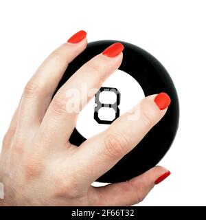 Magic 8 boule de prédictions dans la main femelle avec rouge clous isolés sur fond blanc Banque D'Images