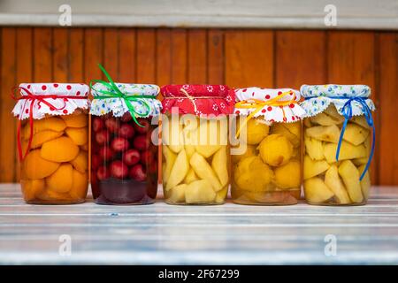 Plats conservés dans un pot, compote de fruits sur une table en bois. Variété de fruits conservés maison dans la cuisine. Compotes d'abricot, de cerise, de poire, de prune et de pomme Banque D'Images