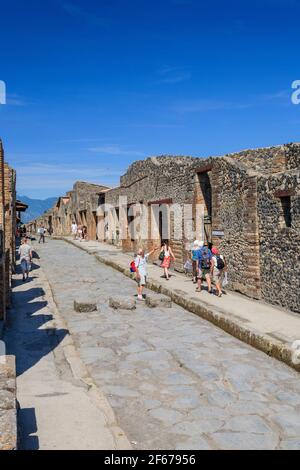 Une rue romaine avec des touristes regardant le panneau d'entrée de la Maison de Rapinasi à Pompéi, Italie Banque D'Images