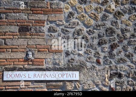 Un panneau de rue et une façade sculptant à l'entrée de la Maison de Rapinasi dans la ville romaine de Pompéi, en Italie Banque D'Images