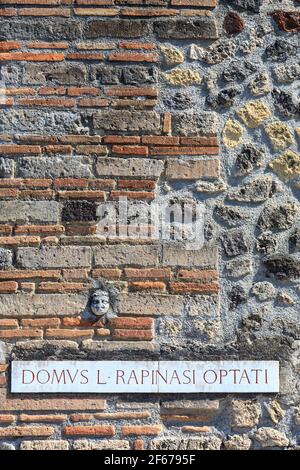 Un panneau de rue et une façade sculptant à l'entrée de la Maison de Rapinasi dans la ville romaine de Pompéi, en Italie Banque D'Images