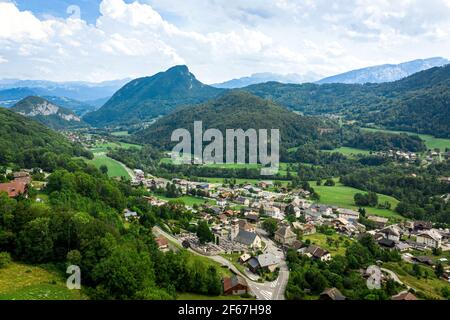 Vue sur le village de montagne entre les collines boisées. Journée d'été dans la vallée de la montagne. Beauté de la région des montagnes de Giffre, France. Banque D'Images