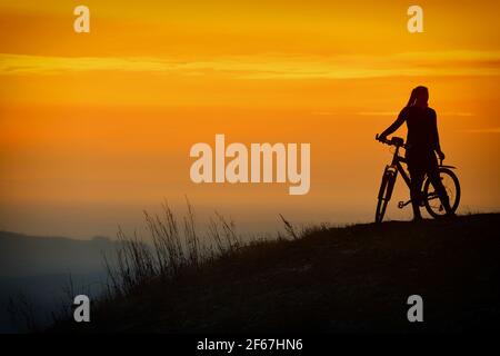 Kozakov, République tchèque. 30 mars 2021. Une femme passe son vélo en début de soirée dans le Paradis tchèque (à 100 kilomètres au nord de Prague) pendant la pandémie COVID-19 en République tchèque. Credit: Slavek Ruta/ZUMA Wire/Alamy Live News Banque D'Images