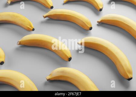 Motif géométrique de bananes sur fond gris. La vue du dessus. Coupe plate minimaliste. Pop art design, créatif été concept. Banque D'Images