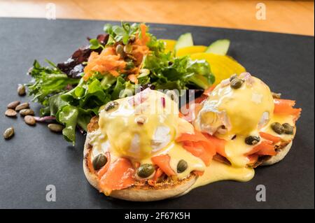 A West Coast oeufs Benedict, oeufs pochés, sauce hollandaise, saumon fumé, oignons, et câpres. Banque D'Images