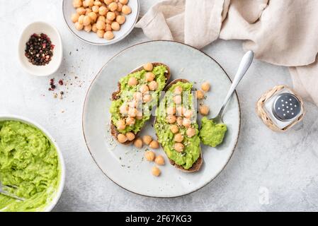 Purée d'avocat et de pois chiches sur du pain grillé. Vue de dessus des toasts végétaliens sains Banque D'Images