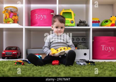 Le jeune garçon caucasien joue avec des jouets colorés Banque D'Images