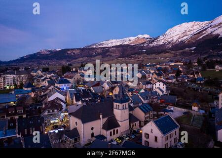 Vue nocturne sur le village de montagne dans les montagnes du Vercors, France. Couche de neige recouvrant la crête de montagne en arrière-plan. Banque D'Images