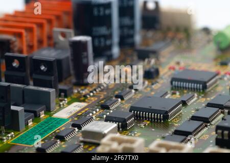 Gros plan de la carte de circuit imprimé électronique avec puce, processeur, circuits intégrés, résistances et connexions électroniques. Banque D'Images