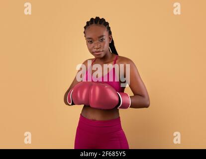Classes d'auto-défense. Portrait de la jeune femme Sporty Black portant des gants de boxe Banque D'Images