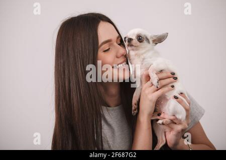 Gros plan sur une femme magnifique qui rit, se câliner avec son petit chien Banque D'Images