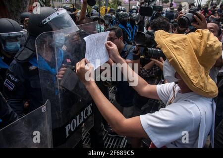 Bangkok, Thaïlande. 30 mars 2021. Un manifestant présente un écriteau exprimant son opinion auprès des policiers anti-émeute pendant la manifestation.des manifestants pro-démocratie se sont rassemblés devant la maison du gouvernement pour réclamer la libération des militants pro-démocratie qui ont été arrêtés en vertu de la loi de la lèse laise (article 112 du code pénal thaïlandais) et exiger des réformes de la monarchie, Abolition de la loi sur la majesté de lèse (article 112) et démission du Premier ministre, Prayut Chan-O-Cha. (Photo de Peerapon Boonyakiat/SOPA Images/Sipa USA) crédit: SIPA USA/Alay Live News Banque D'Images