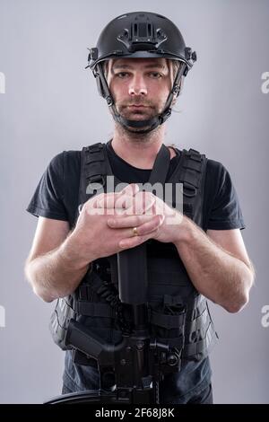 Gros plan portrait d'une armée mariée homme équipé est de poser ses mains sur l'arme. Prise de vue isolée en studio Banque D'Images