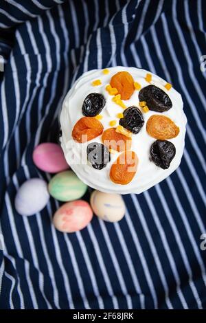 Les œufs de Pâques décorés d'aquarelles et de gâteau de Pâques sont placés sur un tablier bleu rayé. Concept de vacances religieuses de Pâques, vue de dessus Banque D'Images