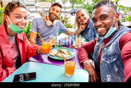 Des amis prenant le selfie dans un bar-restaurant avec masque de visage Banque D'Images