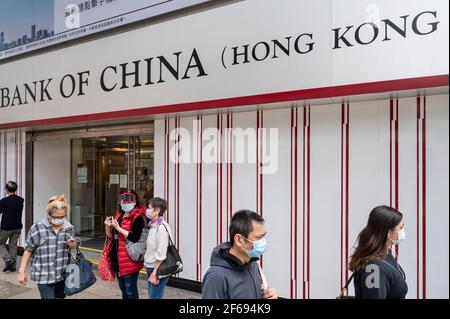 Hong Kong, Chine. 24 mars 2021. Des piétons portant des masques faciaux se promisent devant la filiale de la Banque de Chine, la société bancaire commerciale publique chinoise, à Hong Kong. Crédit: Budrul Chukrut/SOPA Images/ZUMA Wire/Alay Live News Banque D'Images