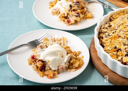 Crumble aux pommes et aux poires avec crème glacée, streusel. Crème glacée servie au mélange croustillant d'avoine et de fruits. Tarte aux pommes avec noix. Vue latérale. Deux assiettes avec dessert diététique sans gluten à faible teneur en calories. Banque D'Images