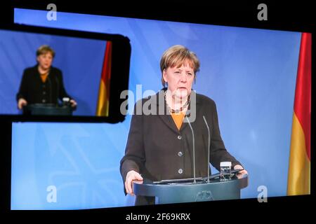 Berlin, Allemagne. 30 mars 2021. Photo prise à Berlin, en Allemagne, le 30 mars 2021, des écrans présentant la chancelière allemande Angela Merkel à l'occasion d'une conférence de presse à l'issue d'une réunion des gouvernements fédéral et des États allemands sur le vaccin AstraZeneca. Le vaccin AstraZeneca COVID-19 ne doit généralement être utilisé que pour les personnes âgées de 60 ans et plus à partir de mercredi, les gouvernements fédéral et d'État allemands ont décidé mardi soir. Credit: Shan Yuqi/Xinhua/Alay Live News Banque D'Images