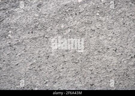 La surface plate d'une pierre gris clair grossièrement travaillée avec de petites taches noires. Arrière-plan, motif, texture. Banque D'Images