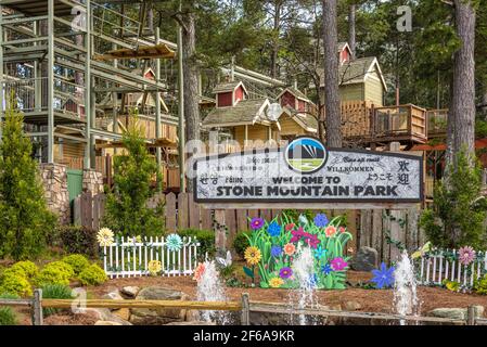 Signe de bienvenue au Stone Mountain Park à Atlanta, Géorgie avec parcours de cordes d'aventure en famille SkyHike en arrière-plan. (ÉTATS-UNIS) Banque D'Images