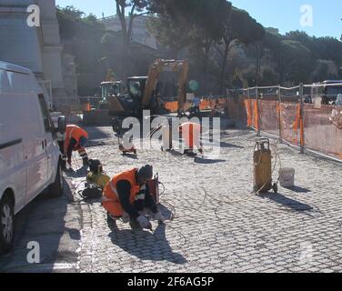 ROM, Italie. 19 novembre 2020. Les ouvriers du bâtiment posent des pavés sur la Piazza Venezia. La relation des Romains avec leurs pavés traditionnels a quelque chose de fou à ce sujet. Certains l'appellent amour-haine. Les deux roues maudissent les routes cahoteuses dans le centre de la ville de millions de personnes. (À dpa «Roman balancing Act - il y a toujours marteler sur les pavés") Credit: Petra Kaminsky/dpa/Alamy Live News Banque D'Images