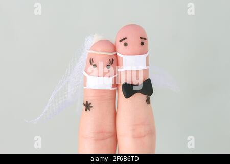 Fingers art de couple heureux dans le masque médical de COVID-2019. Concept de cérémonie de mariage. Banque D'Images