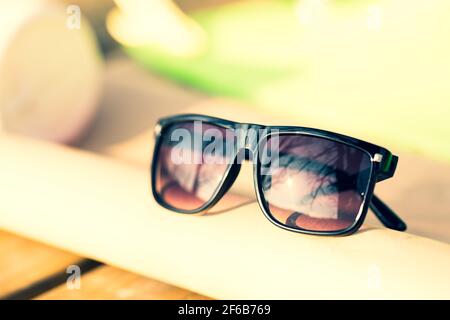 Lunettes de soleil classiques pour hommes et femmes avec verres noirs et cadre noir Shoot à l'extérieur dans une journée d'été gros plan. Mise au point sélective Banque D'Images