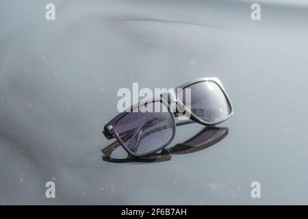 Lunettes de soleil classiques pour hommes et femmes avec verres noirs et cadre noir Shoot à l'extérieur dans une journée d'été gros plan. Mise au point sélective Banque D'Images
