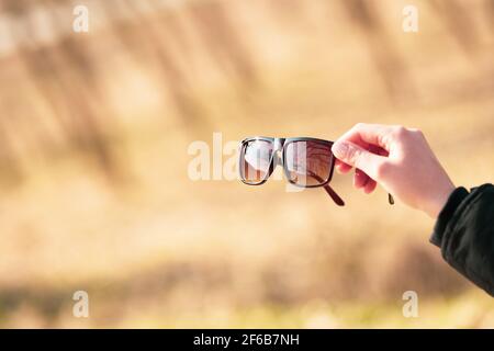Lunettes de soleil classiques design pour hommes et femmes avec verres bruns et cadre brun Shoot à l'extérieur dans un jour d'été gros plan. Mise au point sélective Banque D'Images