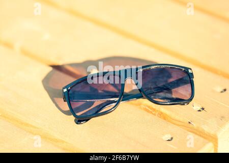 Lunettes de soleil classiques pour hommes et femmes avec verres noirs et cadre noir Shoot à l'extérieur dans une journée d'été gros plan. Mise au point sélective Banque D'Images