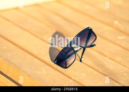Lunettes de soleil classiques pour hommes et femmes avec verres noirs et cadre noir Shoot à l'extérieur dans une journée d'été gros plan. Mise au point sélective Banque D'Images
