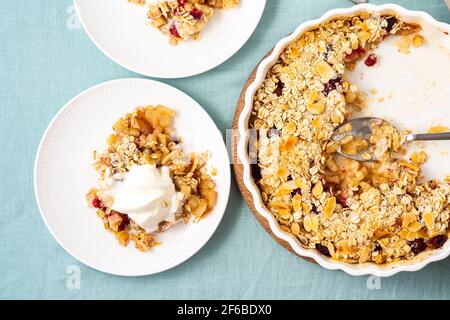 Deux assiettes avec crumble aux pommes et aux poires, streusel sain sans gluten avec avoine, noix. Dessert sucré avec une compote de fruits nappée d'un mélange croustillant de crème glacée servie. Tarte aux pommes et au régime, vue du dessus Banque D'Images