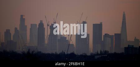 Wimbledon, Londres, Royaume-Uni. 31 mars 2021. Brume légère au lever du soleil sur une vue vers des gratte-ciels éloignés et des grues de construction dans la ville de Londres avant une autre journée de soleil dans la capitale. Crédit : Malcolm Park/Alay Live News Banque D'Images