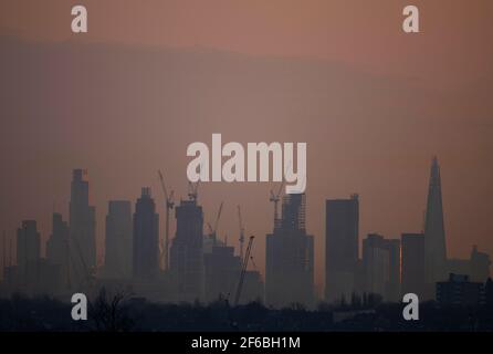 Wimbledon, Londres, Royaume-Uni. 31 mars 2021. Brume légère au lever du soleil sur une vue vers des gratte-ciels éloignés et des grues de construction dans la ville de Londres avant une autre journée de soleil dans la capitale. Crédit : Malcolm Park/Alay Live News Banque D'Images