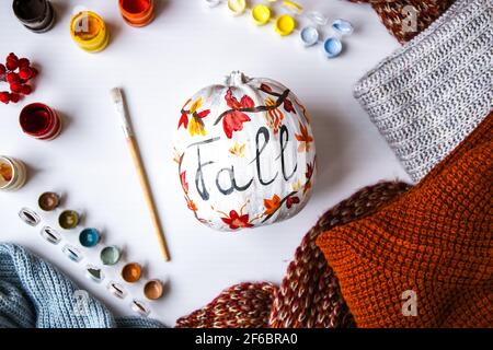 BRICOLAGE. Faites-le vous-même. Une femme peint des décorations d'action de grâce sur la citrouille d'orange pour Halloween. Récolte d'automne. Banque D'Images