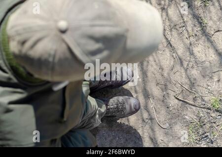 Vue aérienne d'un homme en uniforme militaire. Un soldat dans une casquette verte et des bottes brunes se tient dans la ligne de formation. Jour. Extérieur. Mise au point dans le groupe arrière Banque D'Images
