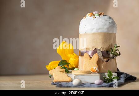 Composition de Pâques avec pain sucré orthodoxe traditionnel. Kulich décoré de glace meringue, d'œufs en forme de bonbons, de biscuits de pâques et de tulipe. Sélectif Banque D'Images