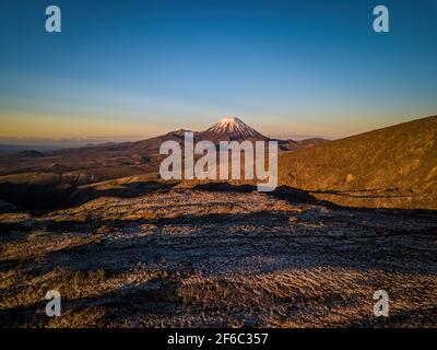 Sommet enneigé du volcan du mont Ngauruhoe au crépuscule. Vue aérienne de la Nouvelle-Zélande paysages et paysages fantastiques. Banque D'Images