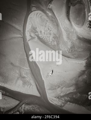 Vue de dessus en noir et blanc de la rivière qui coule à travers le sol sablonneux à l'estuaire. Vue aérienne de la Nouvelle-Zélande paysages et paysages fantastiques. Banque D'Images