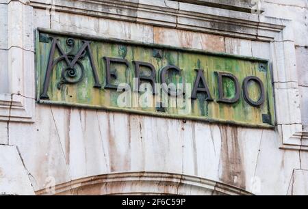 Gros plan du panneau traditionnel du marché (Abastos), en espagnol. En bronze oxydé, avec tons vert et ocre. Banque D'Images
