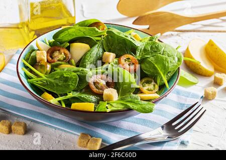 Salade végétarienne saine et appétissante à faible teneur en calories avec pousses d'épinards, pomme fraîche, tomates et pain grillé. Régime méditerranéen. Style maison. Banque D'Images